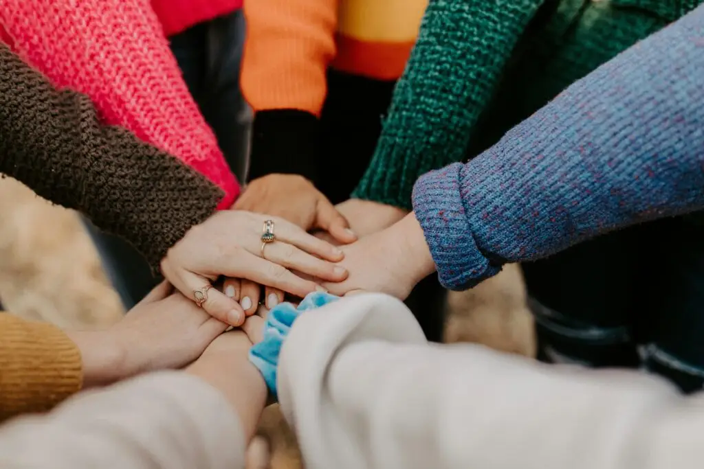 Group of people with hands stacked together in unity and support gesture.